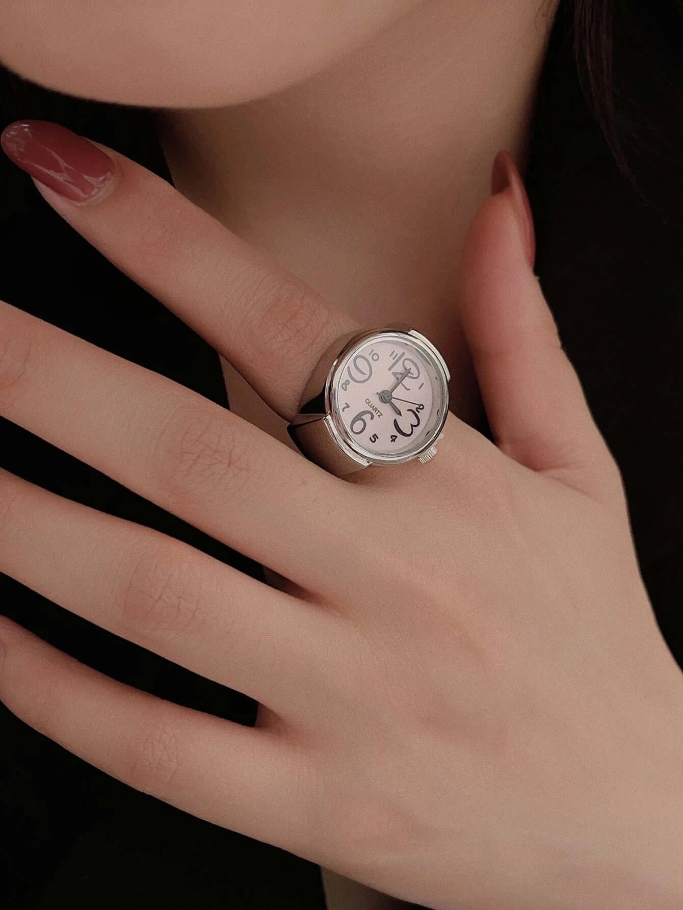 Elegant vintage ring watch worn on a woman's hand displaying a unique dial design.